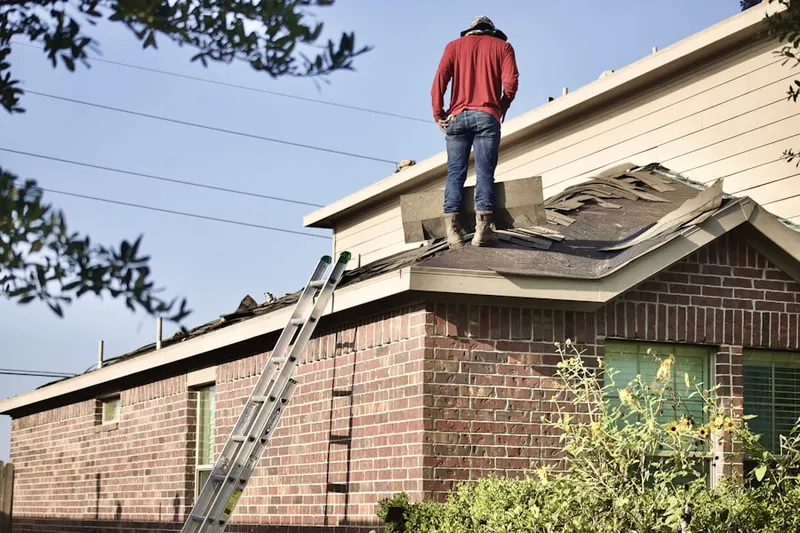Professional roofer working on a residential roof in Hewlett